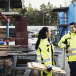 Kvinnlig och manlig byggarbetare samtalar på arbetsplatsen