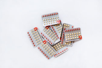 En hög med p-piller-kartor på ett bord