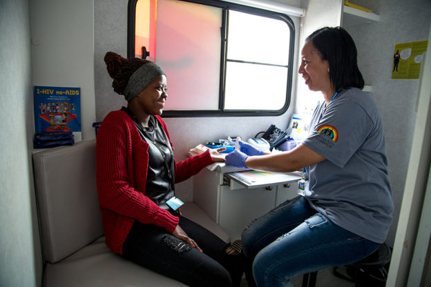 En kvinna blir hiv-testad av en annan kvinna i Tutu Teen Truck