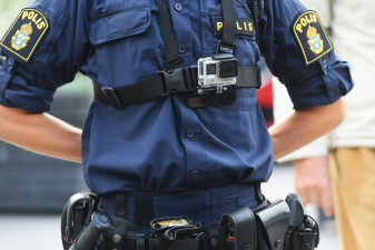 Uniformerad polis med en kamera fastspänd på bröstet