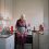 Äldre kvinna med förkläde står i kök