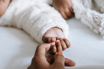 Händer från en förälder och ett litet barn som håller i varandra