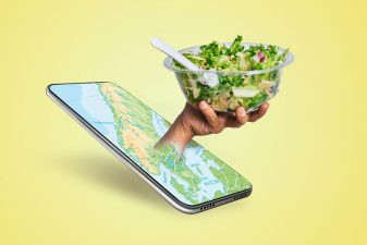 Hand sträcker sig ur en mobiltelefon, med en sallad i handen