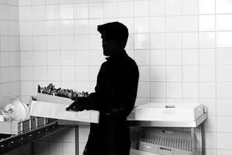 Bild på en man som ser ut att arbeta som diskare. Mannen är skuggad.