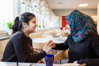 Two girls laughing in school cafeteria