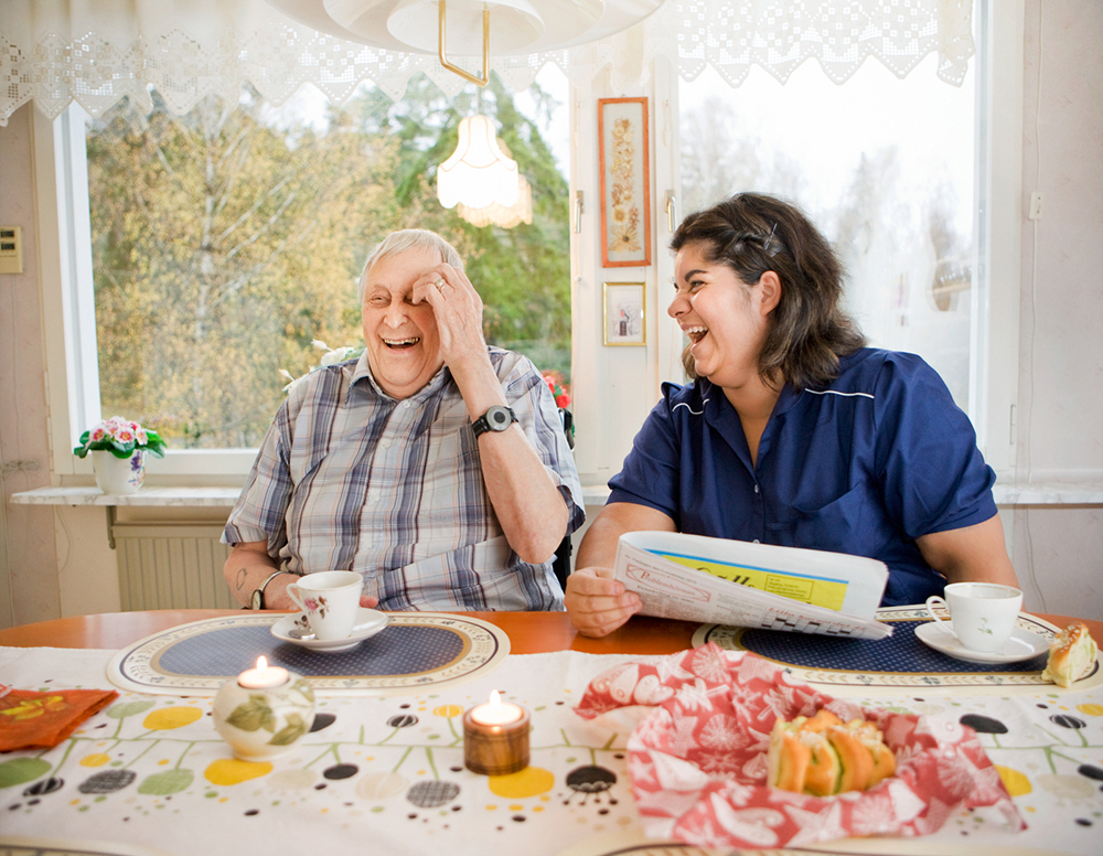Ädre man och kvinna från hemtjänst skrattar tillsammans