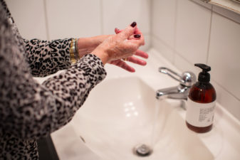Äldre kvinna tvättar händerna