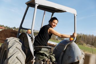 Ung kvinna kör traktor