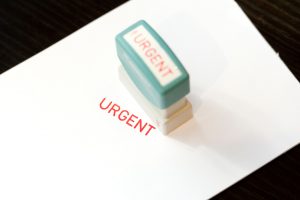 Urgent-stämpel på vitt papper.