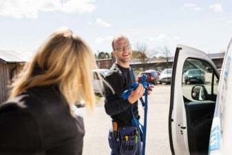 Två elektriker vid sin bil